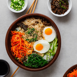 A photograph of a plate of Bibimbap (mixed Rice Bowl), generated by AI