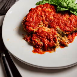 A photograph of a plate of Eggplant Parmesan, generated by AI